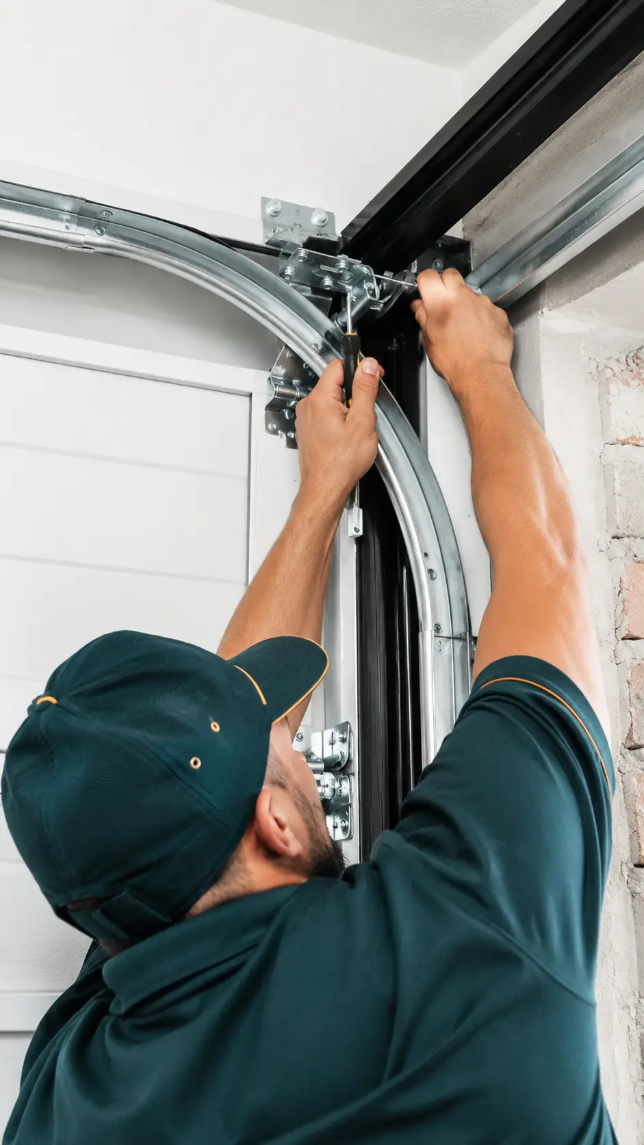 Technician inspecting garage door springs cables rollers and hardware for preventive maintenance in Greenfield Indiana